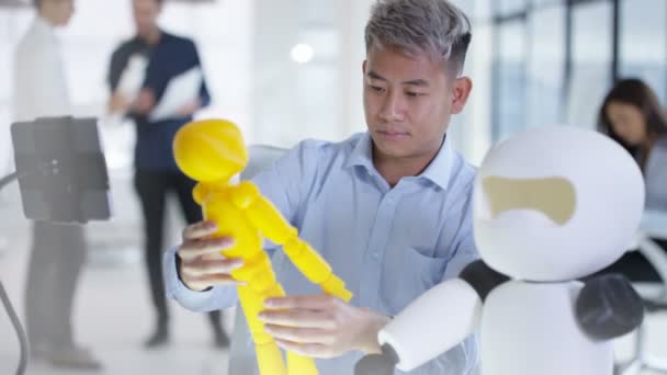 Ingénieur en électronique asiatique 4K travaillant en laboratoire avec un prototype de robot 