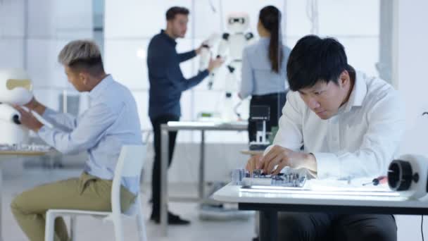 Équipe de conception technique 4K travaillant sur la construction d'un robot dans un laboratoire moderne 