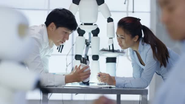 Équipe de conception technique 4K travaillant sur la construction d'un robot dans un laboratoire moderne 