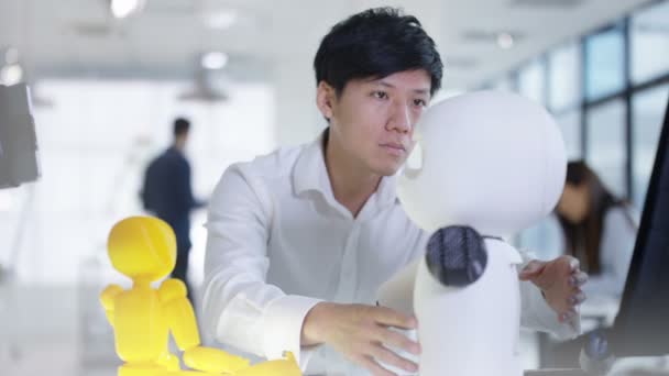 Ingénieur en électronique asiatique 4K travaillant en laboratoire avec un prototype de robot 