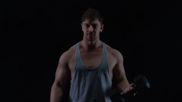 黒の背景に重りを持ち上げる筋肉の体格で フィット若い男 — ストック動画