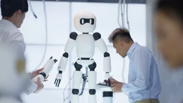 Équipe de conception technique 4K travaillant sur la construction d'un robot dans un laboratoire moderne 