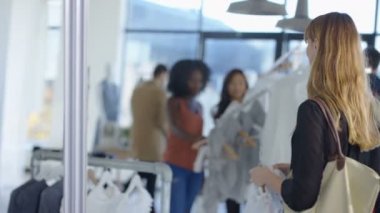 Müşteriler alışveriş ve sayaç moda giyim mağazası satış asistanı.