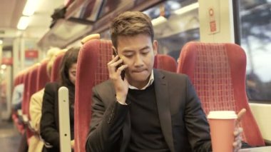 4 k genç Asyalı işadamı meşgul banliyö treni telefonda konuşurken