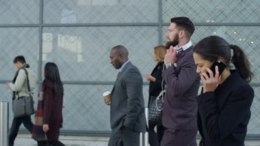 4k Laid geri o çalışmak için yürüyüş olarak kulaklıklar giyen işadamı sakallı.