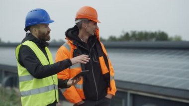 Güneş enerjisi tesisi işlemleri tartışırken bilgisayar tablet ile 4 k teknisyenleri