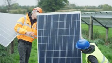 Güneş enerjisi fabrikasında çalışan 4 k teknisyenleri muayene için bir panelini çıkarma