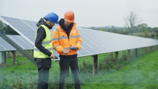 在太阳能工厂工作的技术人员 检查面板和谈话 — 图库视频影像