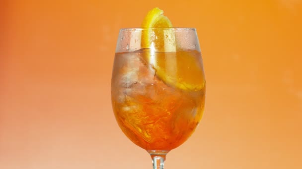 カラフル アイス オレンジ色の背景 スローモーションでガラスの夏の飲み物 — ストック動画