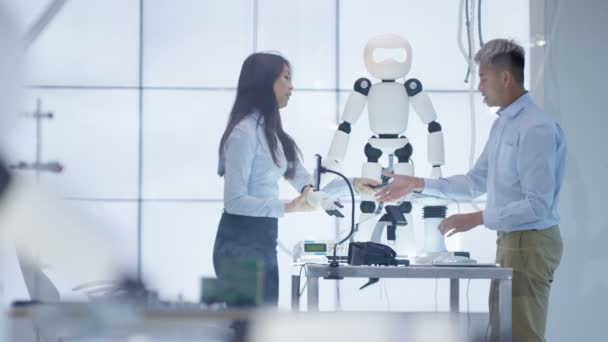 Ingénieurs techniques 4K travaillant sur la construction d'un robot automatisé dans un laboratoire moderne .