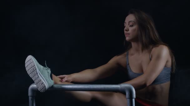 Forma Giovane Donna Allungando Muscoli Delle Gambe Uno Sfondo Nero — Video Stock