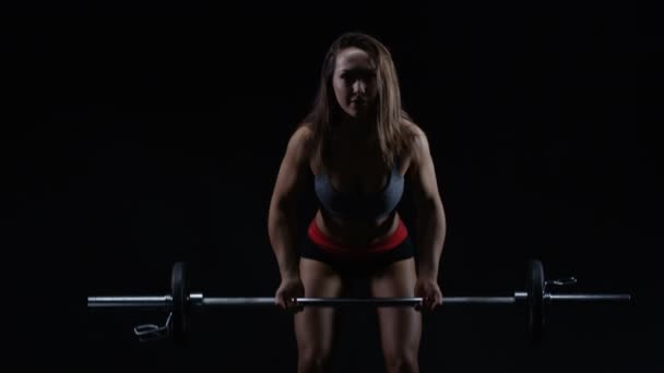 Fit Vrouw Met Atletische Lichaamsbouw Tillen Gewichten Tegen Zwarte Achtergrond — Stockvideo