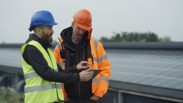 Tekniker Med Dator Surfplatta Diskuterar Verksamheten Vid Solenergi Anläggning — Stockvideo