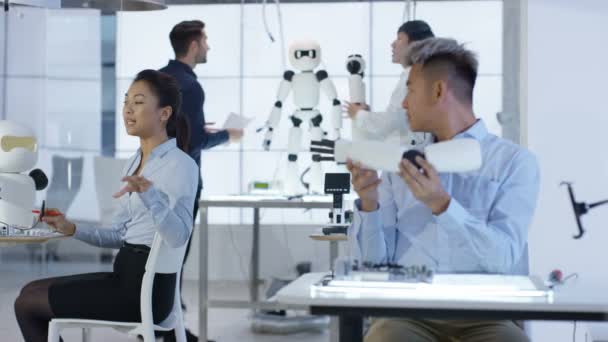 Équipe de conception technique 4K travaillant sur la construction d'un robot dans un laboratoire moderne 