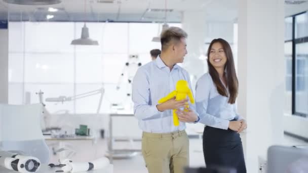 Ingénieurs en électronique asiatiques 4K travaillant en laboratoire avec un prototype de robot 