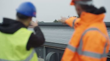 Güneş enerjisi tesisi işlemleri tartışırken bilgisayar tablet ile 4 k teknisyenleri