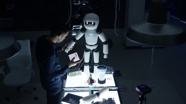 エレクトロニクス エンジニアの暗い研究室でロボットのデザインに取り組んで — ストック動画