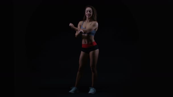 Fit Jonge Vrouw Met Atletische Lichaamsbouw Uitrekken Zich Tegen Zwarte — Stockvideo