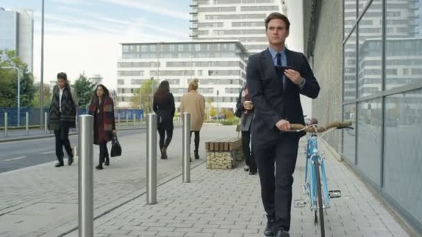 Ung Affärsman Med Cykel Kontrollera Sin Telefon Som Han Promenader — Stockvideo