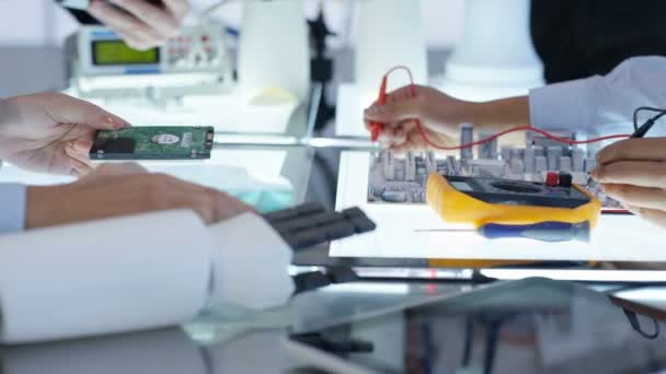 Équipe de conception technique 4K collaborant à la construction d'un robot dans un laboratoire moderne 