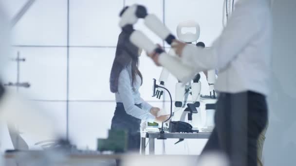 Ingénieurs techniques 4K travaillant sur la construction d'un robot automatisé dans un laboratoire moderne .