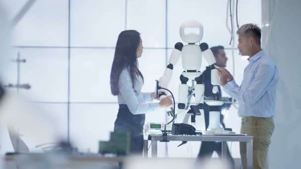 Ingénieurs techniques 4K travaillant sur la construction d'un robot automatisé dans un laboratoire moderne .