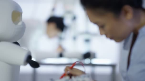 Équipe de conception technique 4K travaillant sur la construction d'un robot dans un laboratoire moderne 