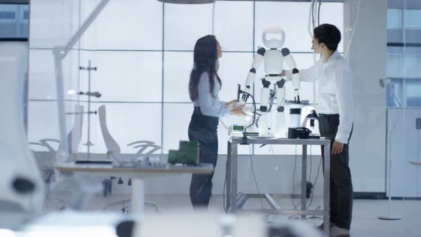 Ingénieurs techniques 4K travaillant ensemble sur un projet de construction de robot 