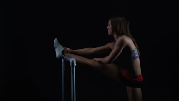 Uygun Genç Kadın Siyah Bir Arka Plan Bacak Kasları Germe — Stok video