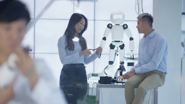 Équipe de conception technique 4K travaillant sur la construction d'un robot dans un laboratoire moderne 