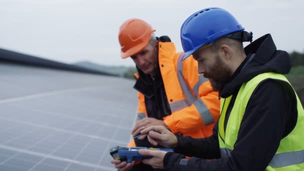 Techniker Überprüfen Die Paneele Bei Der Installation Von Solarenergie — Stockvideo