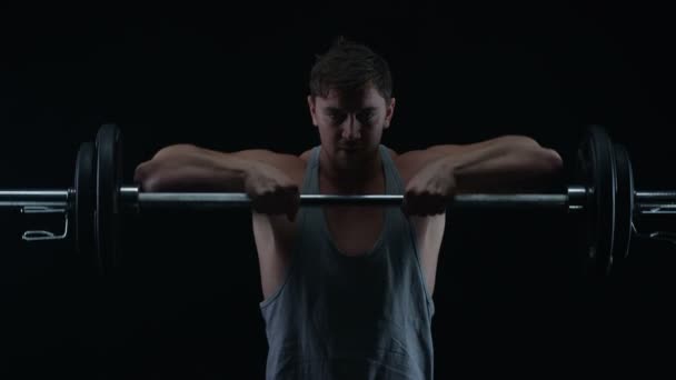 黒の背景に重りを持ち上げる筋肉の体格で フィット若い男 — ストック動画