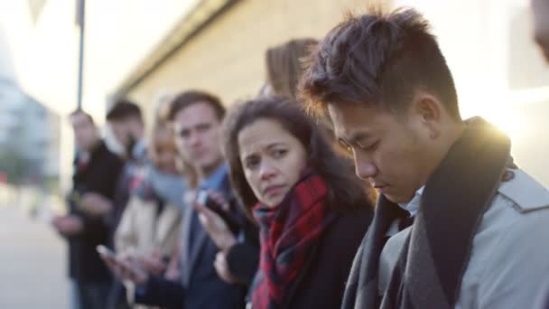 Diverse Unternehmensgruppe Schaut Auf Smartphones Während Sie Der Schlange Steht — Stockvideo