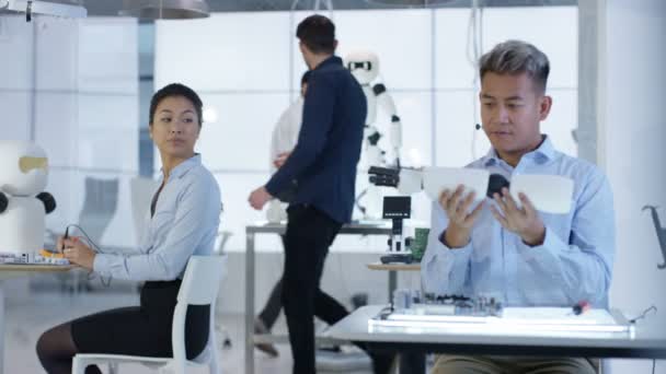 Équipe de conception technique 4K travaillant sur la construction d'un robot dans un laboratoire moderne 