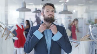 Moda Giyim Mağazası aynaya bakarak bir takım üzerinde çalışıyor ve erkek müşteri. Arka planda alışveriş diğer müşteriler ile Mirror's pov görüldü.