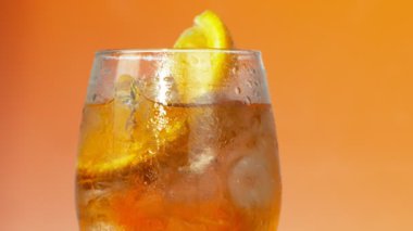 4k renkli buzlu yaz içeceği olarak bir bardak portakal arka planda, ağır çekim