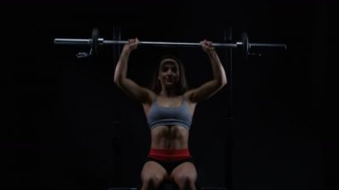 4k genç kadın ağırlık terbiye, oturur pozisyonda halter kaldırma uygun