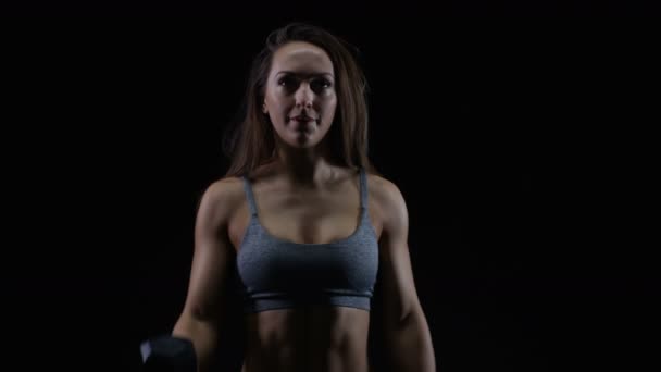 Fit Vrouw Met Atletische Lichaamsbouw Tillen Gewichten Tegen Zwarte Achtergrond — Stockvideo