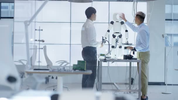 Ingénieurs techniques 4K travaillant ensemble sur un projet de construction de robot 