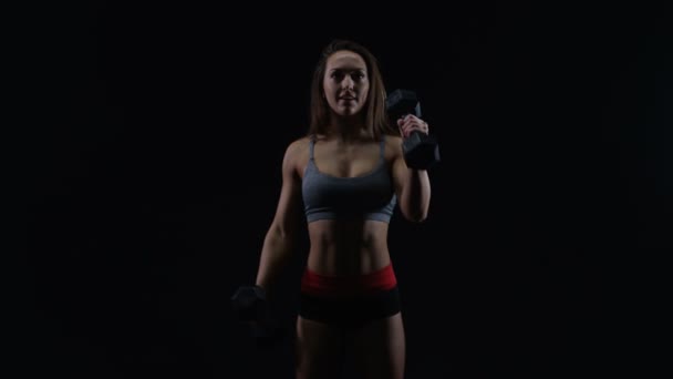黒の背景に重りを持ち上げる運動 Physique フィット女 — ストック動画