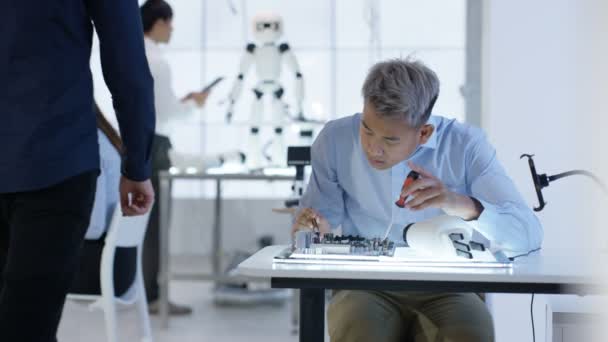 Équipe de conception technique 4K travaillant sur la construction d'un robot dans un laboratoire moderne 