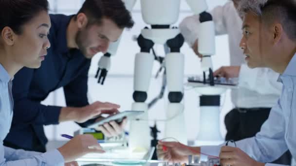 Équipe de conception technique 4K collaborant à la construction d'un robot dans un laboratoire moderne 