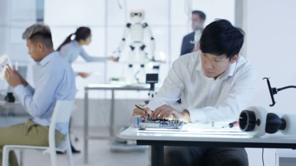 Équipe de conception technique 4K travaillant sur la construction d'un robot dans un laboratoire moderne 