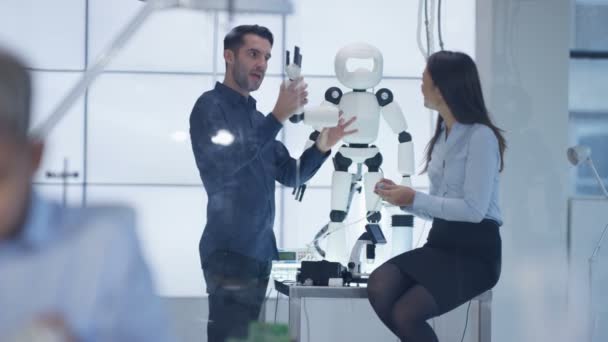 Concepteurs techniques 4K collaborant à la construction d'un robot dans un laboratoire moderne 