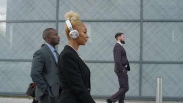 当她走路上班时 穿着耳机的轻松女商人 — 图库视频影像