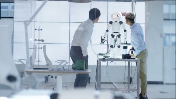 Ingénieurs techniques 4K travaillant ensemble sur un projet de construction de robot 