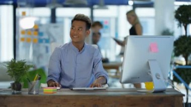 modern ofis masasında çalışan ve kadın meslektaşım konuşurken Asyalı adam.