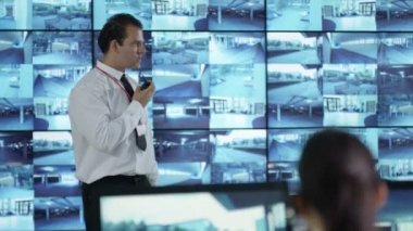 4k güvenlik takım izlemek Cctv ekranları kontrol odasında, memur radyoda konuşma