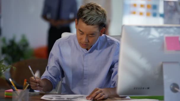Junger Asiatischer Geschäftsmann Telefoniert Modernen Büro Mit Kollegen Die Hintergrund — Stockvideo
