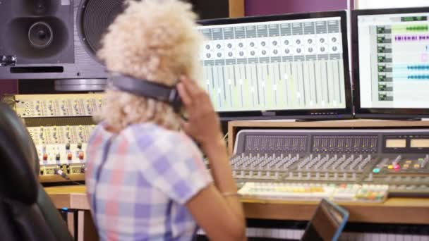 年轻音响工程师在录音室在调音台使用笔记本电脑 — 图库视频影像